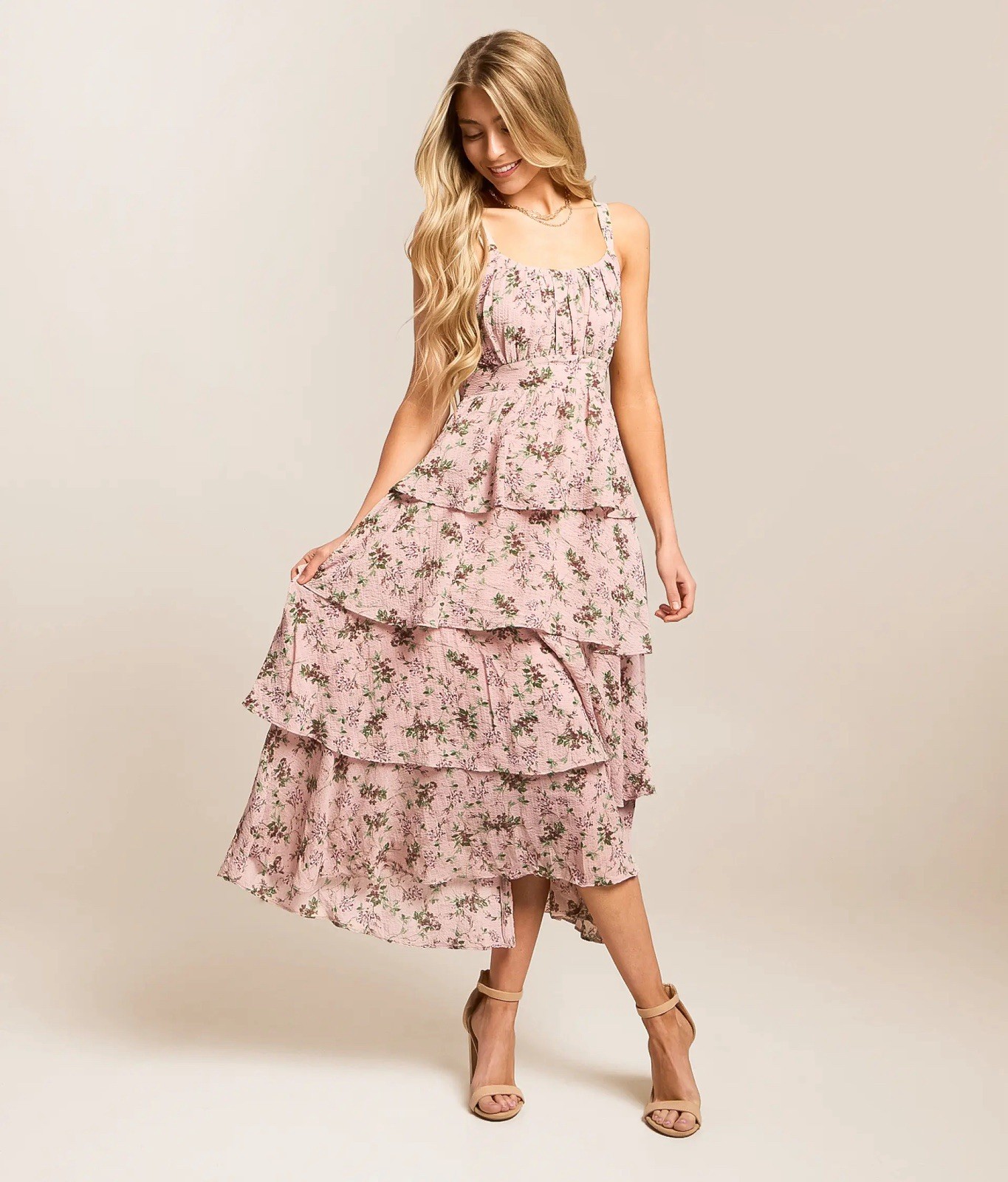 A soft pink floral tiered midi dress with adjustable straps.