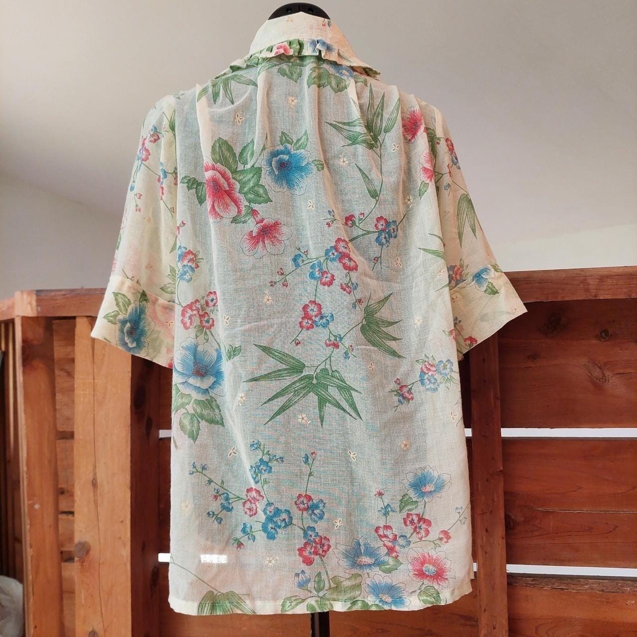 Vintage cream red, blue, and green floral short sleeve top with ruffle detail.