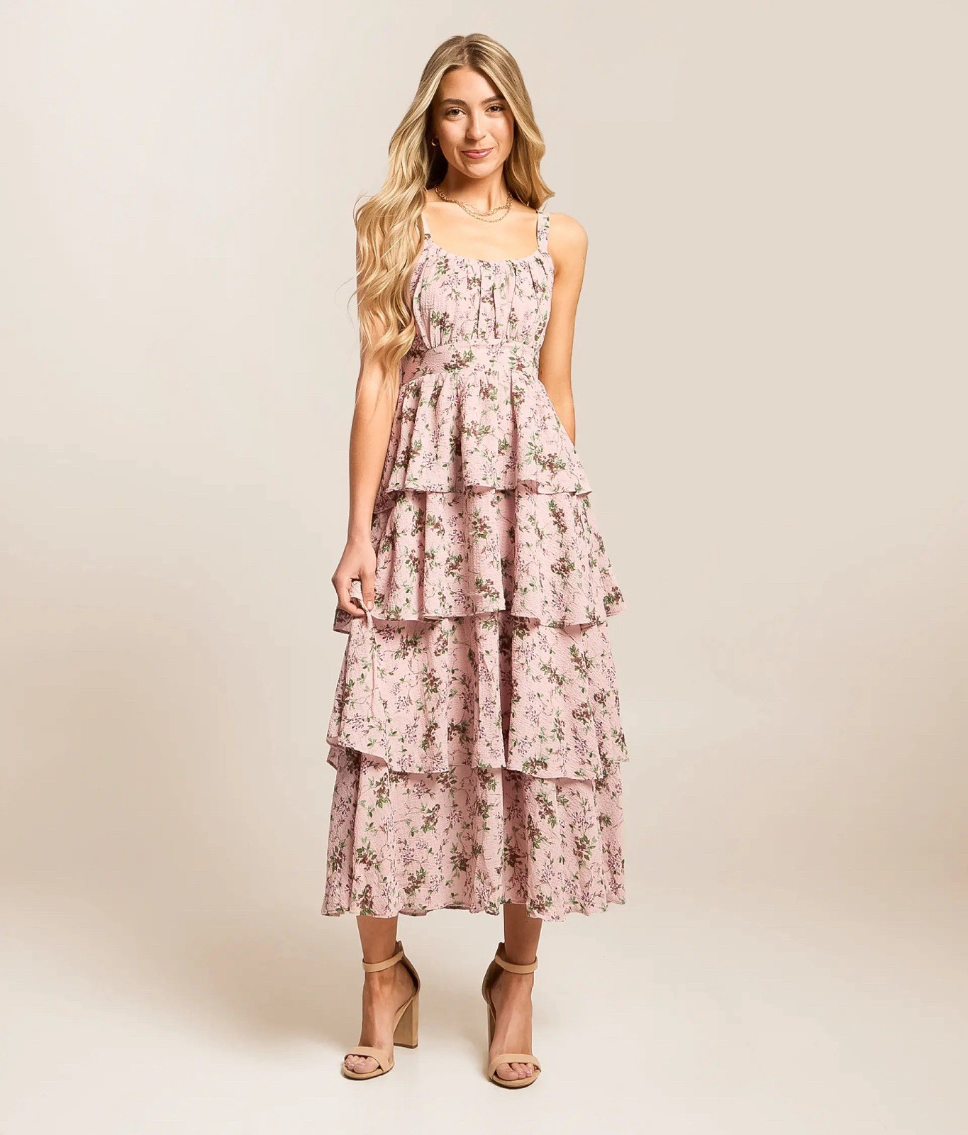 A soft pink floral tiered midi dress with adjustable straps.