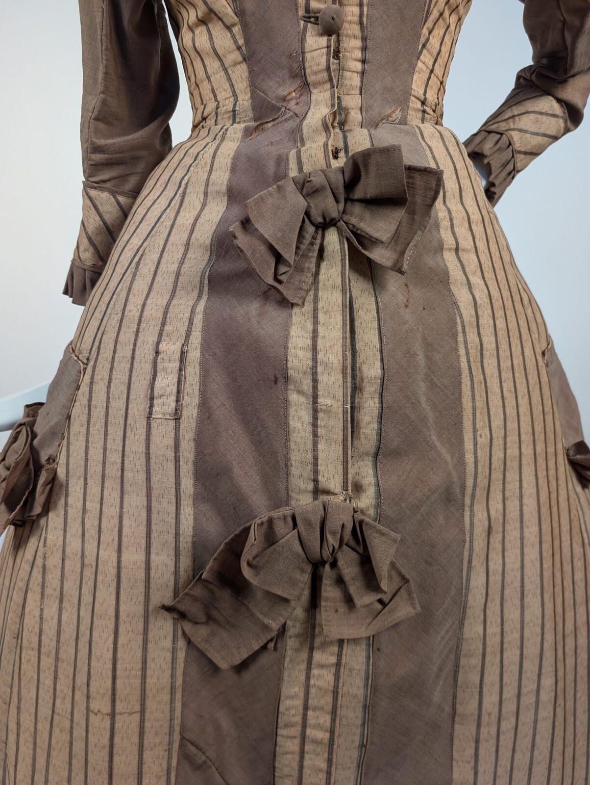 LATE 1860’S PINSTRIPED TAN BOMBAZINE DRESS W BOWS + SIDE POCKET DETAIL