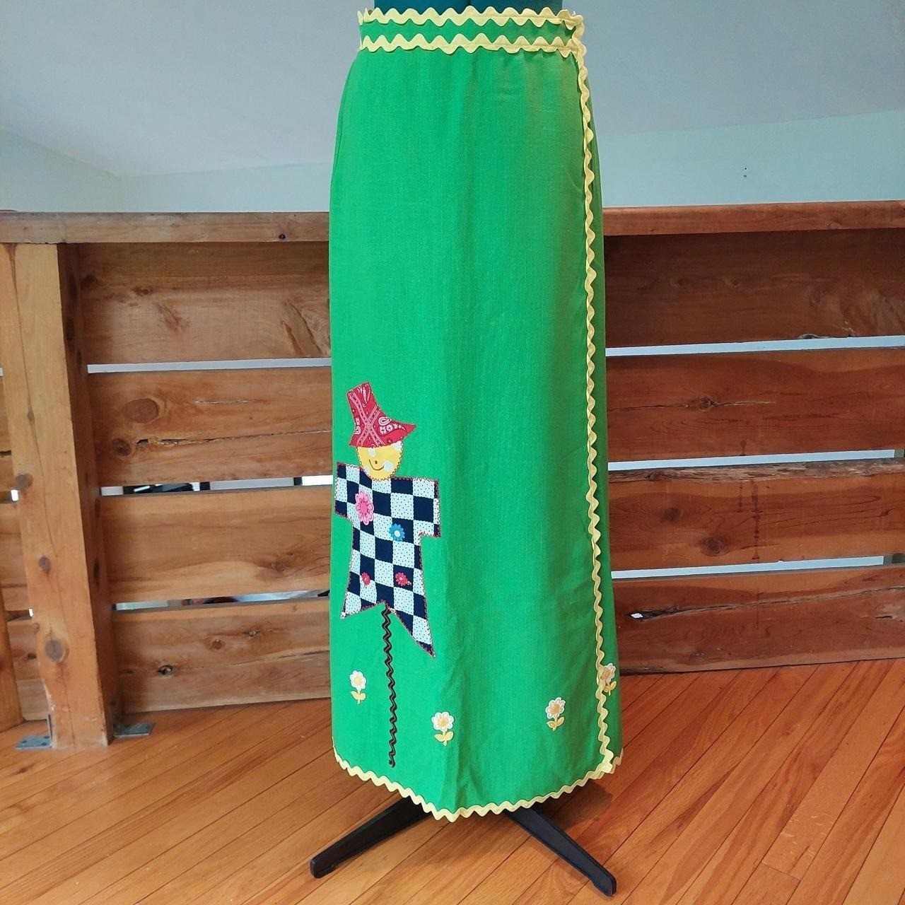 Vintage green and yellow wrap skirt with floral and scarecrow detail.