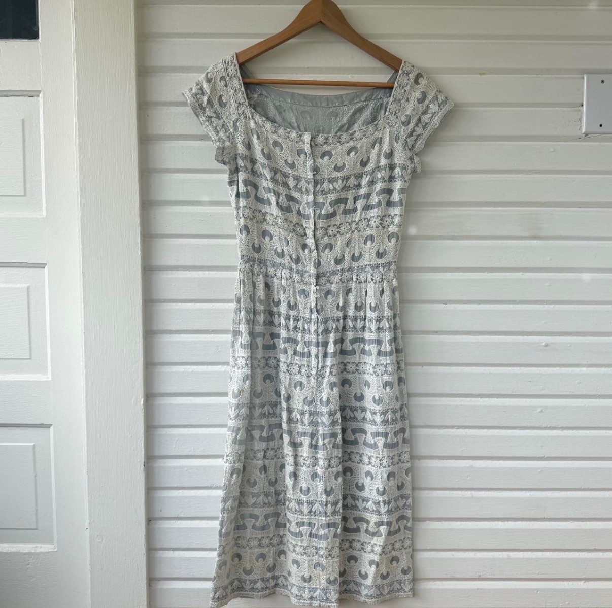 Vintage dress featuring white embroidery on soft powder blue fabric, size 6.