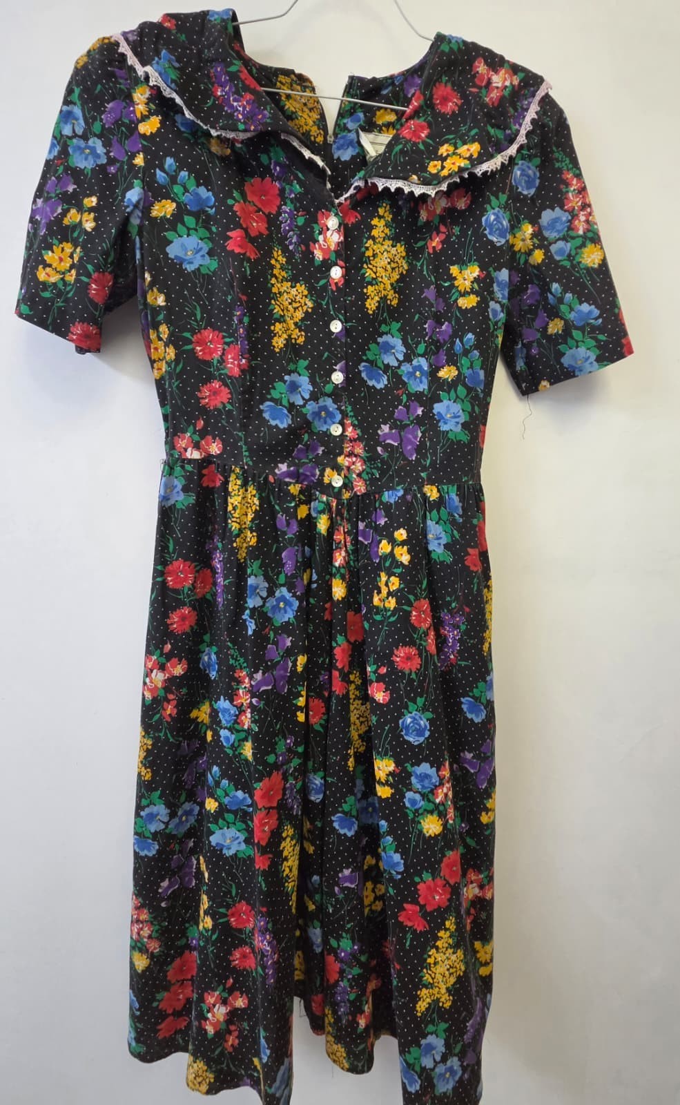 vintage-style dress features a vibrant multicolor floral print against a black