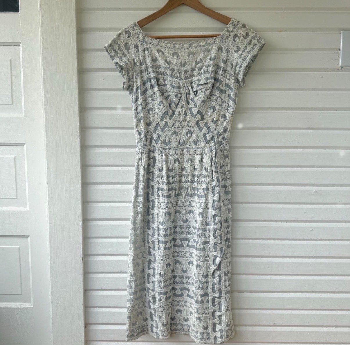 Vintage dress featuring white embroidery on soft powder blue fabric, size 6.