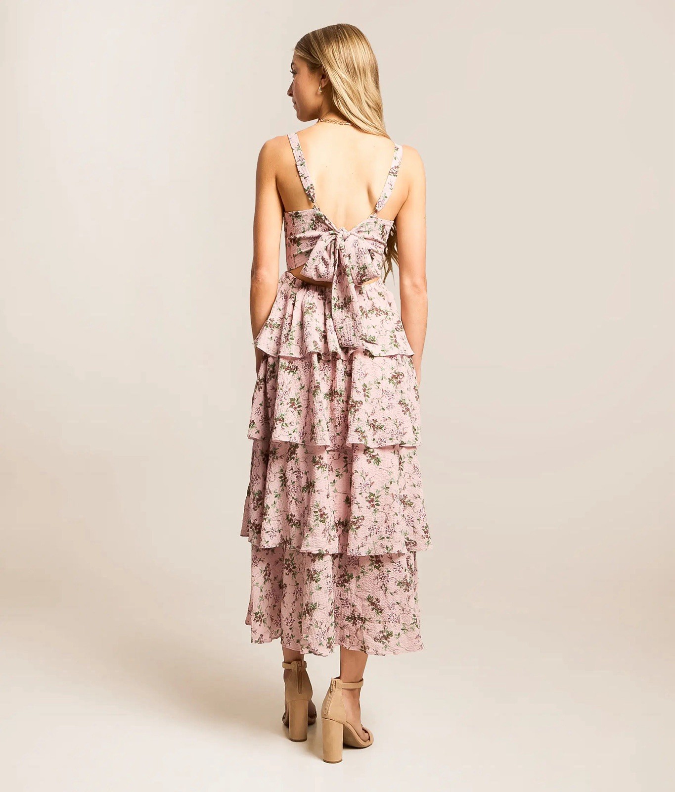 A soft pink floral tiered midi dress with adjustable straps.